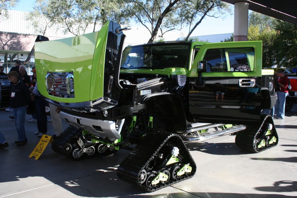 Customized truck with lime green hood and doors, black body, and tank treads instead of wheels