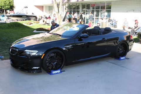 1998 Ford Crown Victoria - A black convertible with custom wheels and JST badging is displayed outdoors.