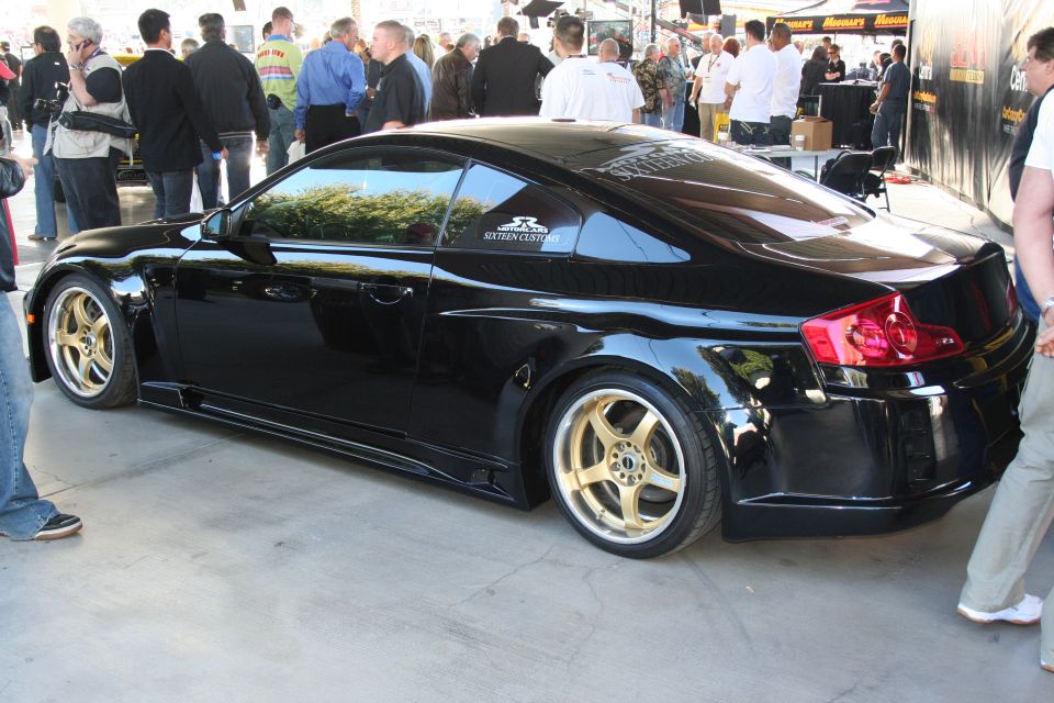 Black coupe with gold rims and custom body kit, rear 3/4 view
