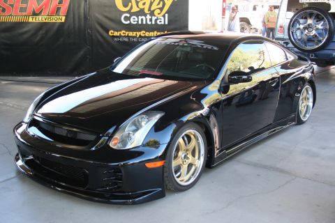 1998 Ford Crown Victoria - Customized black coupe with gold wheels and body kit displayed indoors.