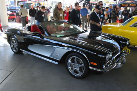 1998 Ford Crown Victoria - A black convertible with a silver accent on its side is displayed at an outdoor event.