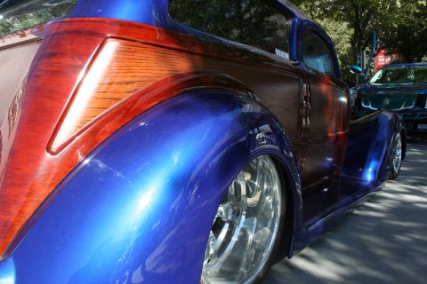 1998 Ford Crown Victoria - A custom hot rod with a unique wood grain paint job is parked outdoors.