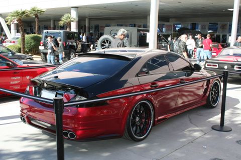 1998 Ford Crown Victoria - A customized coupe with a two-tone red and black paint scheme is displayed at an outdoor event.