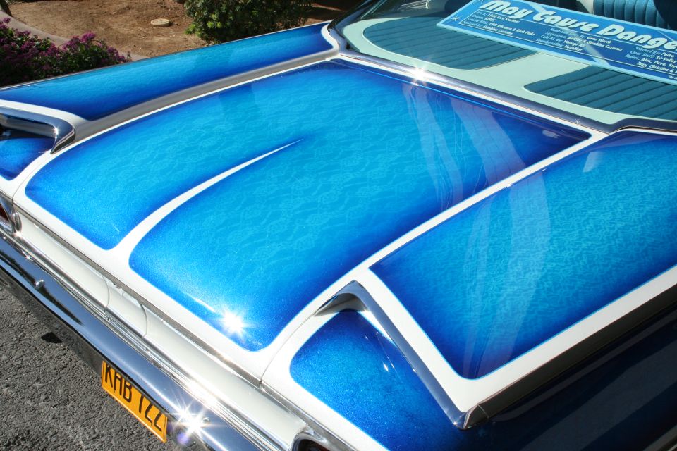 Trunk of a classic car with a custom blue paint job and white trim. License plate reads KHB 1ZZ