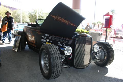 1998 Ford Crown Victoria - A black hot rod with its hood open is displayed outdoors, custom paint and numerous decals.