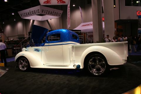 1998 Ford Crown Victoria - A customized pickup truck with a two-tone paint scheme is displayed indoors.