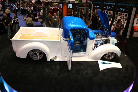 1998 Ford Crown Victoria - A customized pickup truck with a two-tone paint job is displayed indoors with its hood and doors open.