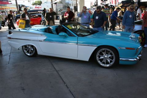 1998 Ford Crown Victoria - A custom convertible with a two-tone paint scheme and fins is displayed at an outdoor event.