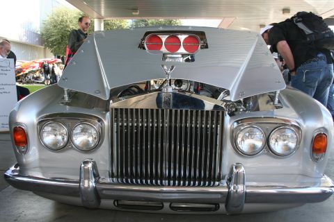 1998 Ford Crown Victoria - This custom Rolls-Royce features an open hood revealing its engine and prominent triple red air intakes.