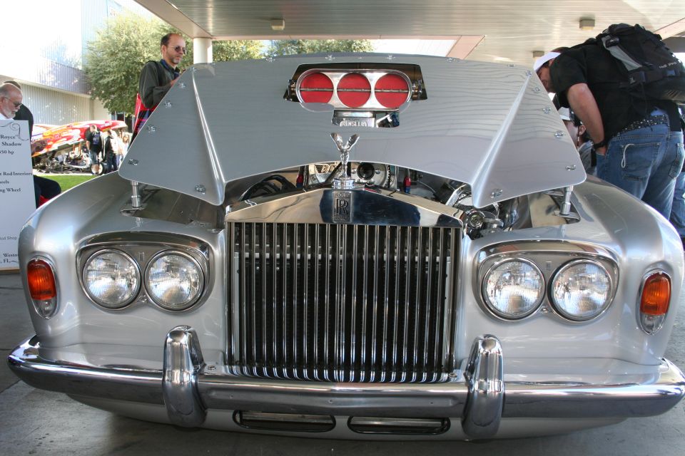 Silver Rolls-Royce with hood open, showing engine and triple red air intakes