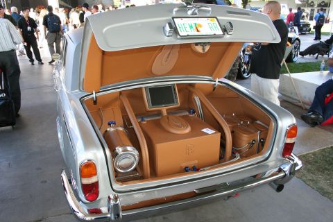 1998 Ford Crown Victoria - Rear view of a custom Rolls-Royce Silver Shadow with its trunk open, revealing a tan leather interior with a screen and storage.