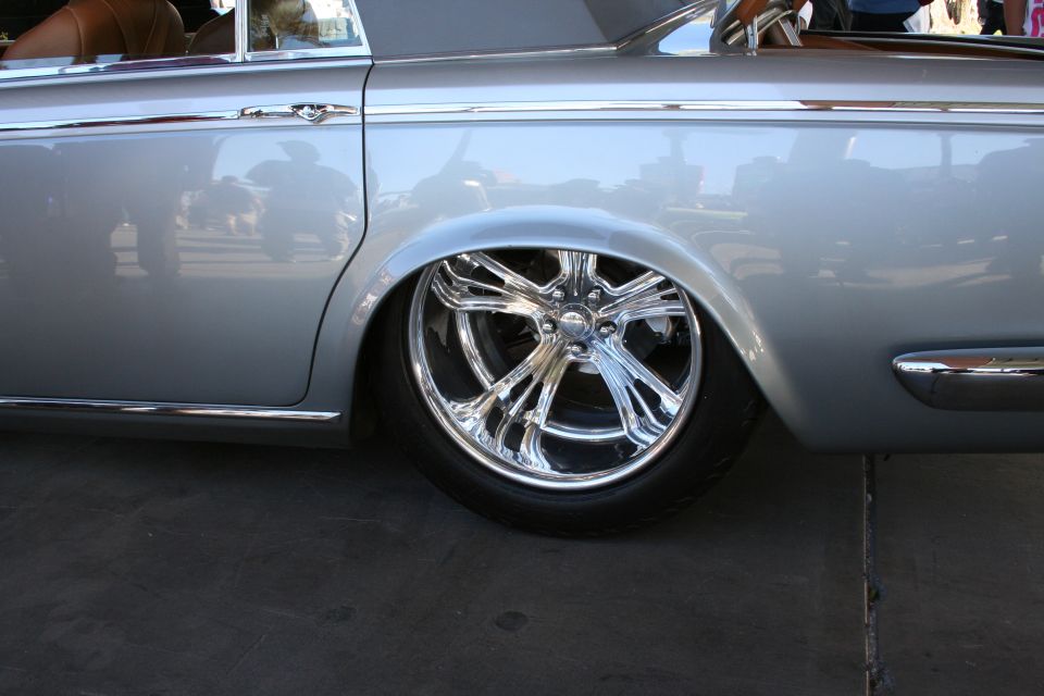 Silver sedan side view with chrome wheels and lowered suspension