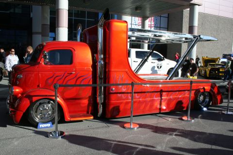 1998 Ford Crown Victoria - A custom tow truck with flame graphics is displayed, carrying another vehicle on its trailer.