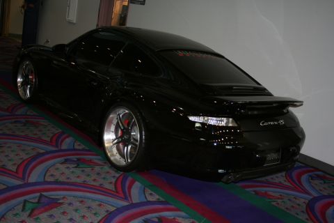 1998 Ford Crown Victoria - Rear view of a black Porsche 911 Carrera S with custom wheels.