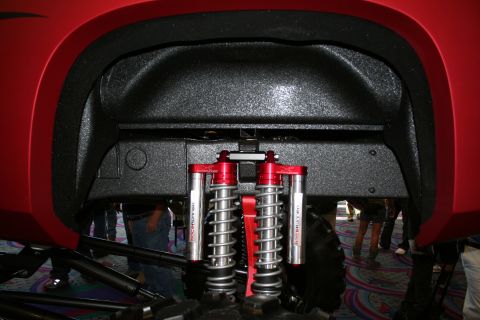 1998 Ford Crown Victoria - Close-up view of the rear suspension system on a red vehicle, dual shock absorbers and coil springs.