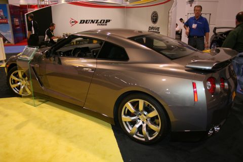 1998 Ford Crown Victoria - A gray Nissan GT-R coupe is displayed indoors with a Dunlop Tires banner in the background.