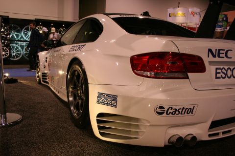 1998 Ford Crown Victoria - A white race car with prominent racing decals like NEC, Escort, and Castrol is displayed indoors.