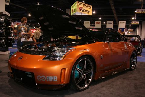 1998 Ford Crown Victoria - An orange sports car is on display with its hood open, revealing the engine compartment.
