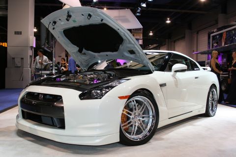 1998 Ford Crown Victoria - A white sports car is displayed with its hood open, revealing the engine and custom modifications.