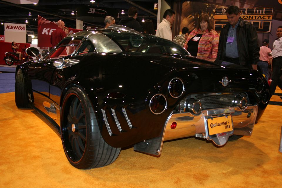 Rear view of a black custom sports car with chrome accents and large wheels. License plate reads 'Continental Tire'