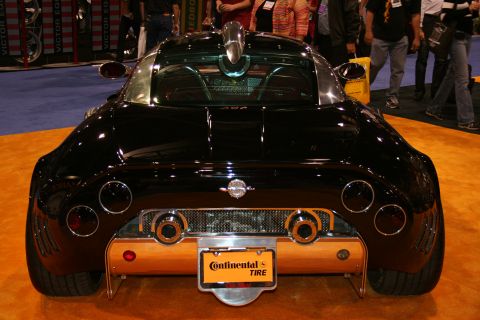 1998 Ford Crown Victoria - Rear view of a black sports car with distinctive circular taillights and dual exhaust pipes.