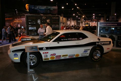 1998 Ford Crown Victoria - White Dodge Challenger drag car with Mopar branding and sponsor decals on display at an event.