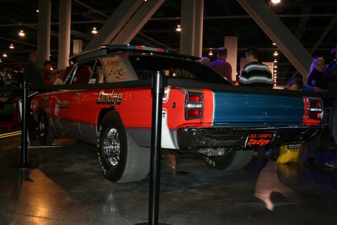 1998 Ford Crown Victoria - Rear view of a Dodge race car with distinctive livery and racing tires on display.