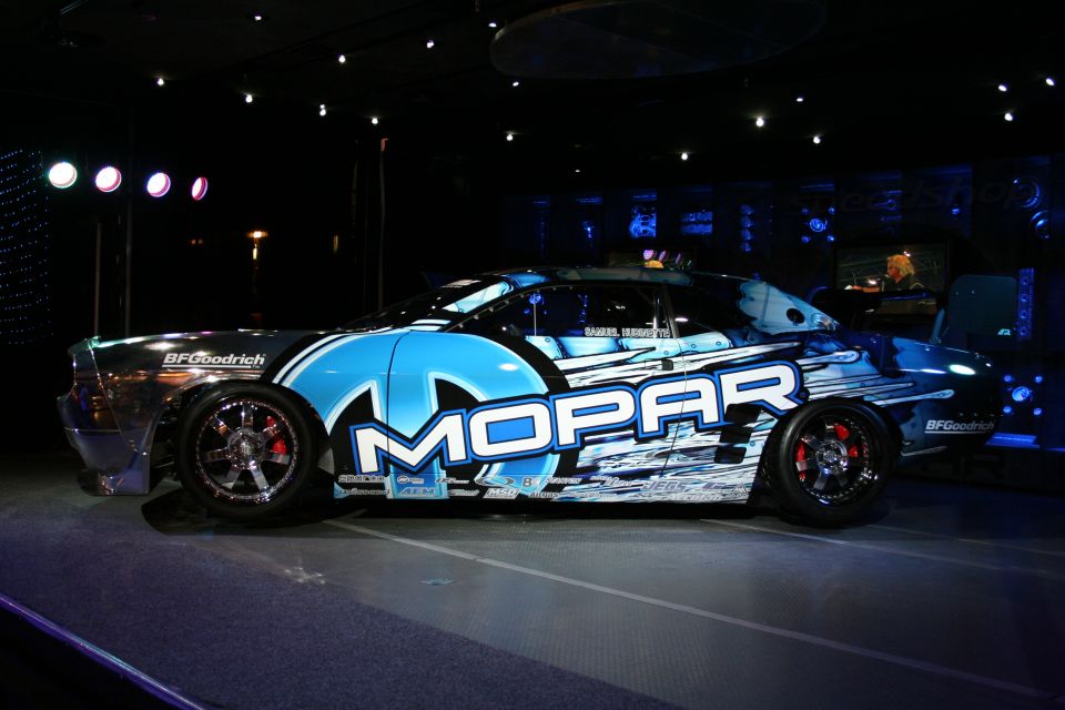 Mopar branded race car with blue and white graphics, side view