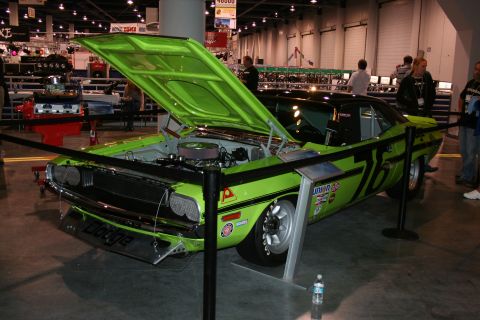 1998 Ford Crown Victoria - Lime green Dodge Challenger with racing decals and hood open at an auto show.