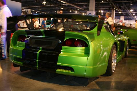 1998 Ford Crown Victoria - Bright green sports car with black stripes and a large rear wing at an indoor event.