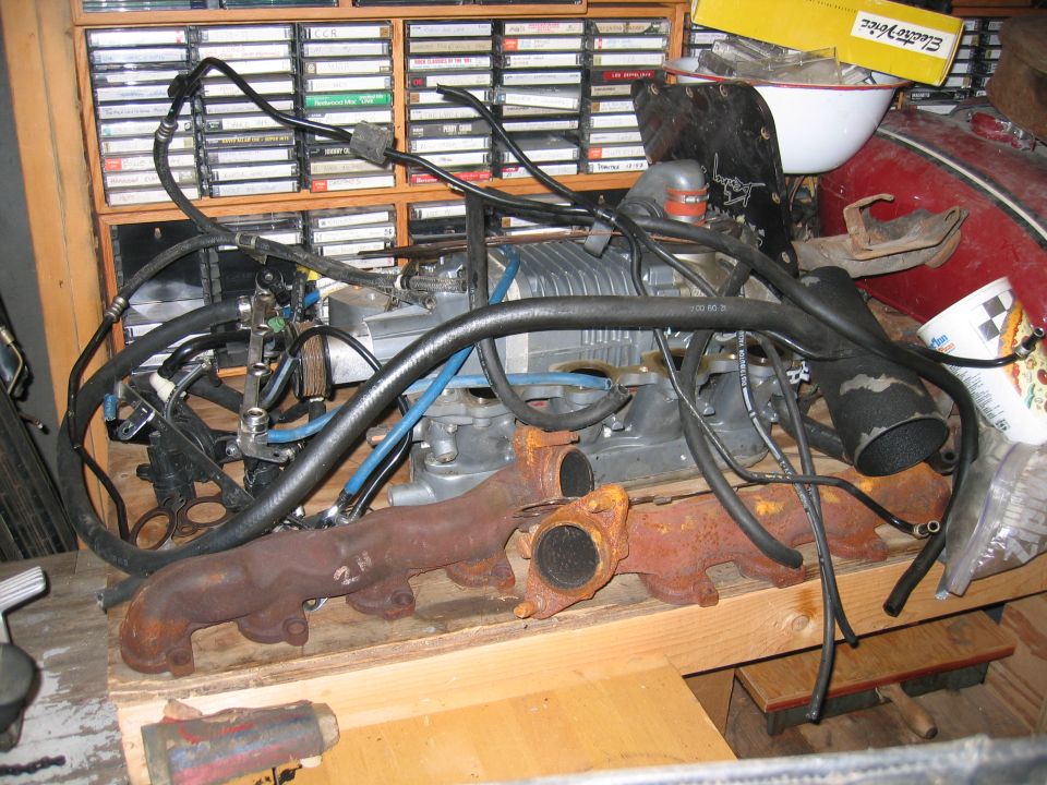Engine part with exhaust manifold and supercharger