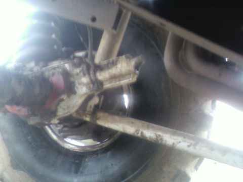 1992 Ford F-350 - Close-up view of the undercarriage, showing suspension parts and a tire. Text from "SUPERMOTORS" is visible at the bottom right.