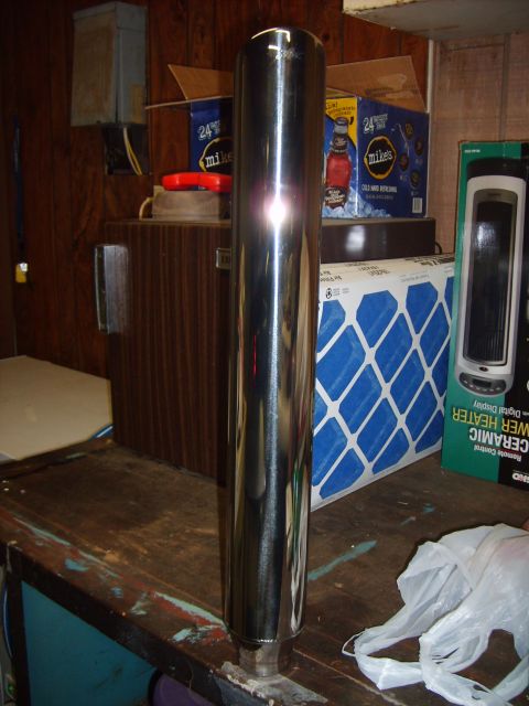 1993 Ford Crown Victoria - A chrome exhaust pipe is shown in front of various boxes and a heater on a wooden surface.