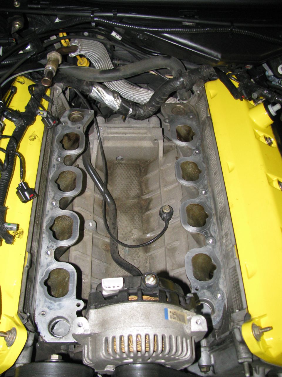 Engine intake manifold with yellow valve covers and alternator
