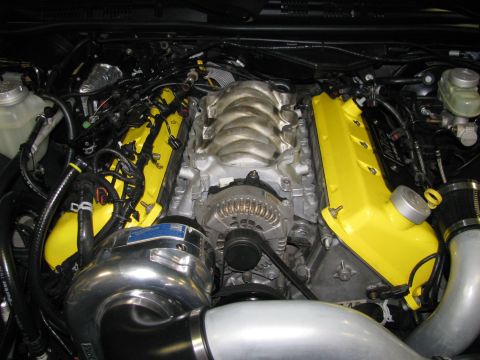 2003 Mercury Marauder - Engine bay yellow valve covers and a prominent supercharger, suggesting performance modifications.