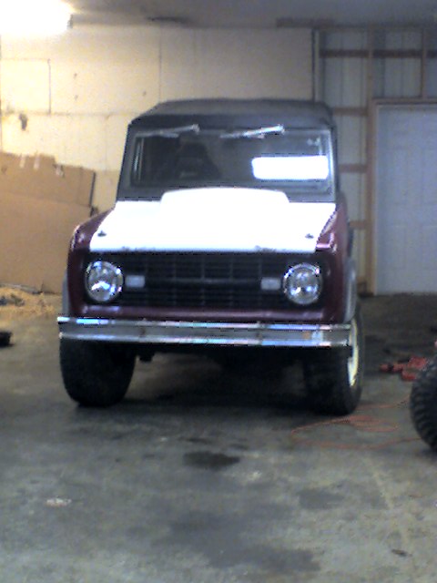 1968 Ford Bronco - Front view of a maroon 1968 Ford Bronco with a white hood, parked indoors.