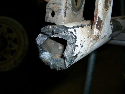1992 Ford F-350 - Close-up of a heavily damaged axle housing, showing signs of significant wear and tear.