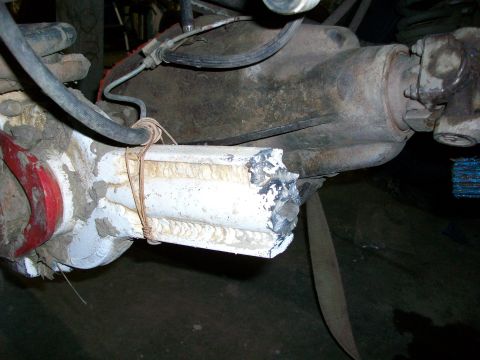 1992 Ford F-350 - Close-up of a damaged axle tube on a rear axle housing, secured with rope.