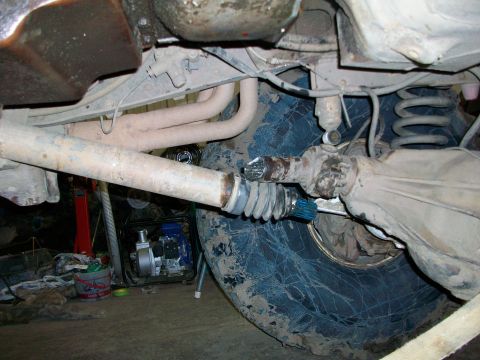 1992 Ford F-350 - Underside view of a vehicle's drivetrain and suspension system, with a generator in the background.
