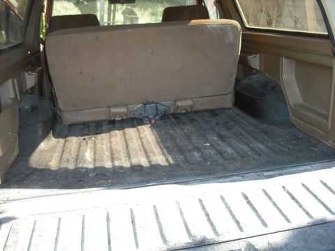 1988 Ford Bronco - Interior view of the cargo area in a 1988 Ford Bronco, showing the folded rear seat.
