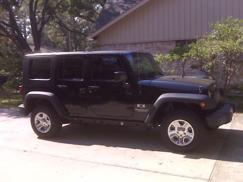 2008 Jeep Wrangler - A black Jeep Wrangler is parked in front of a house.