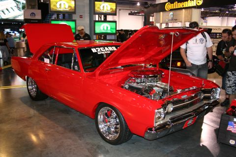 1998 Ford Crown Victoria - Red classic car on display with its engine compartment open.