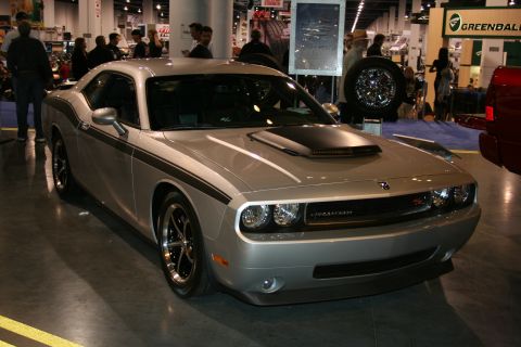 1998 Ford Crown Victoria - A silver Dodge Challenger is displayed indoors, racing stripes and a prominent hood scoop.