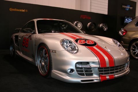 1998 Ford Crown Victoria - This silver Porsche 911 features prominent red racing stripes and the number 58, suggesting a racing heritage.
