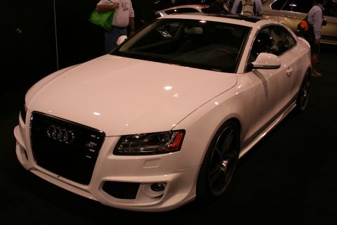 1998 Ford Crown Victoria - A white Audi coupe is displayed indoors with a black grille and dark wheels.