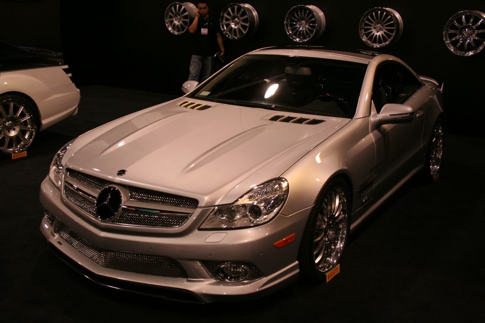 Silver Mercedes-Benz SL-Class coupe with custom wheels, another car partially visible to the left