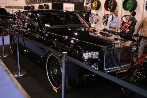 1998 Ford Crown Victoria - A black Rolls-Royce Phantom is displayed with custom wheels and a lowered stance.