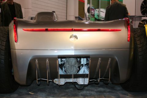 1998 Ford Crown Victoria - The rear of a custom concept car displays a full-width LED taillight and an exposed drivetrain, with large tires on either side.