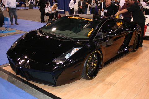 1998 Ford Crown Victoria - A black sports car with custom yellow accents on the wheels is displayed indoors.