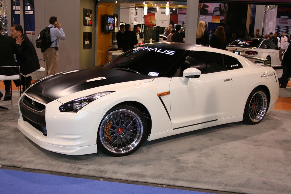 White and black sports car with custom wheels and a black hood